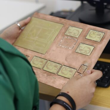 a technician holding an electric board with copper blocks