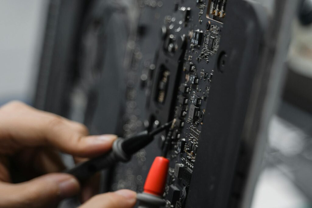 Photo of a person’s hands working on a printed circuit board